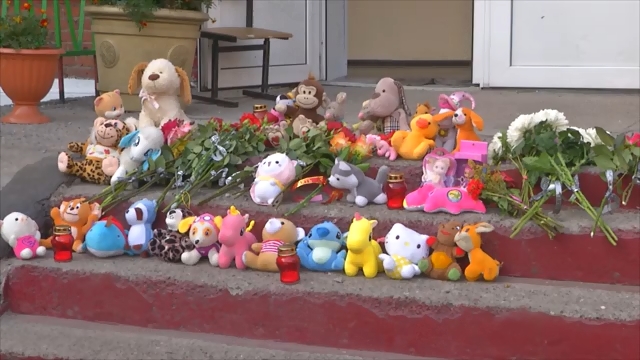 Горожане несут цветы к стихийному мемориалу возле школы №25